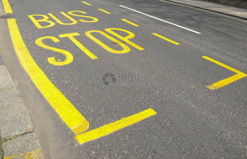 公共汽车站街道上的黄漆公共汽车站牌图片