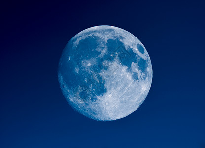 用望远镜看到的高对比度满月用天文望远镜在蓝天上看到的高对比度满月图片