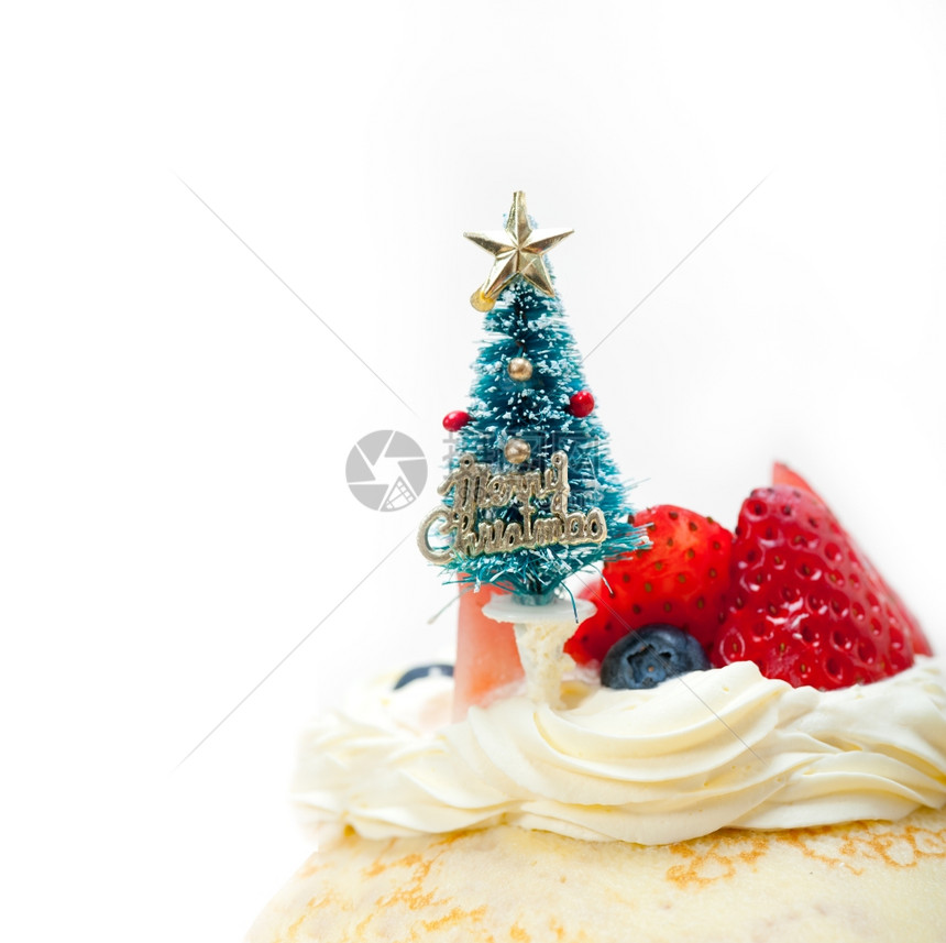 圣诞树在煎饼山顶上带奶油和草莓的鲜图片
