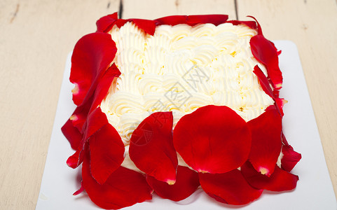 带红玫瑰花瓣的奶油芒果蛋糕图片