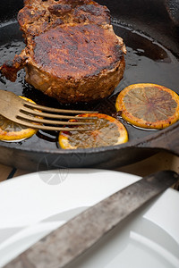 用加柠檬和香料调味的铁椰子烤熟猪肉图片