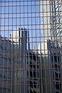 蓝色天空和建筑物反射的玻璃墙图片