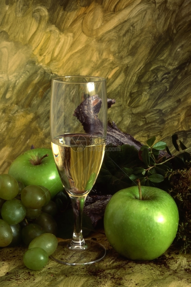 一杯白葡萄酒彩漆背景上多水果图片