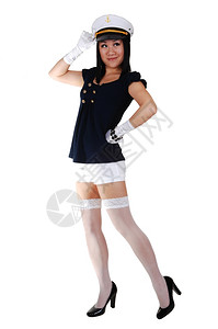 海军敬礼一个年轻的亚洲美女穿着水手制服白短裤长袜和手套穿着高跟鞋和水手帽站在工作室敬礼背景
