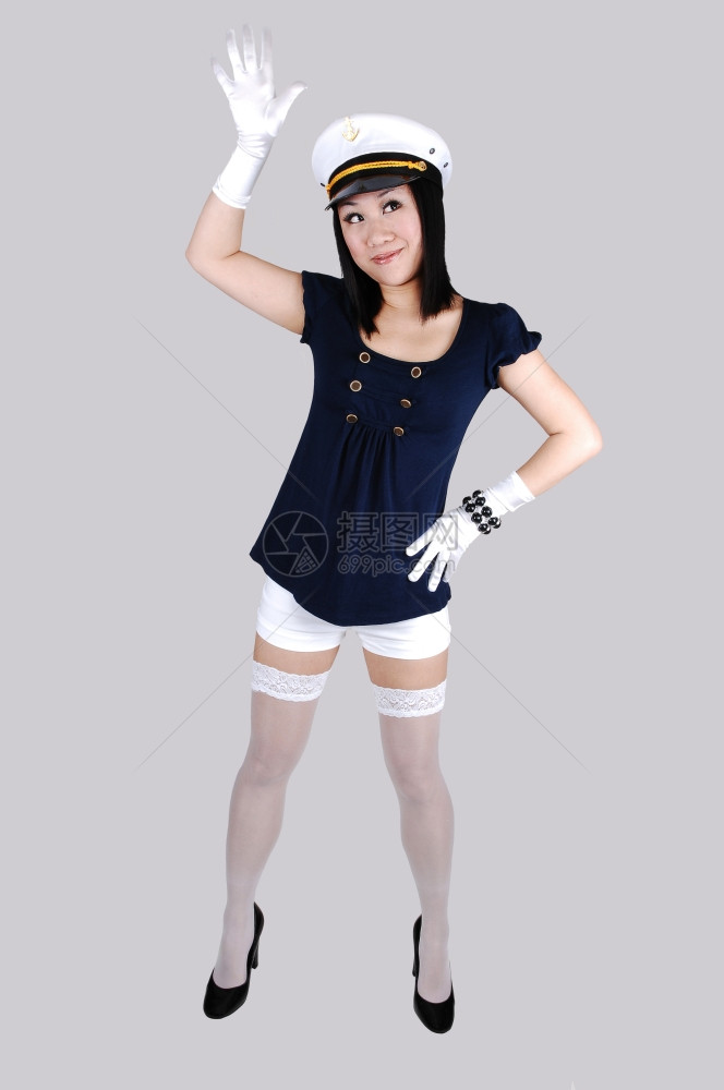 穿着白短裤和丝袜的年轻女子穿着白短裤和丝袜海军蓝皮和白斑站在工作室里寻找白背景图片