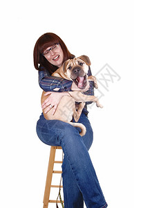 可爱的红发女人抱着小狗大腿却为了白底黑的狗打倒了图片