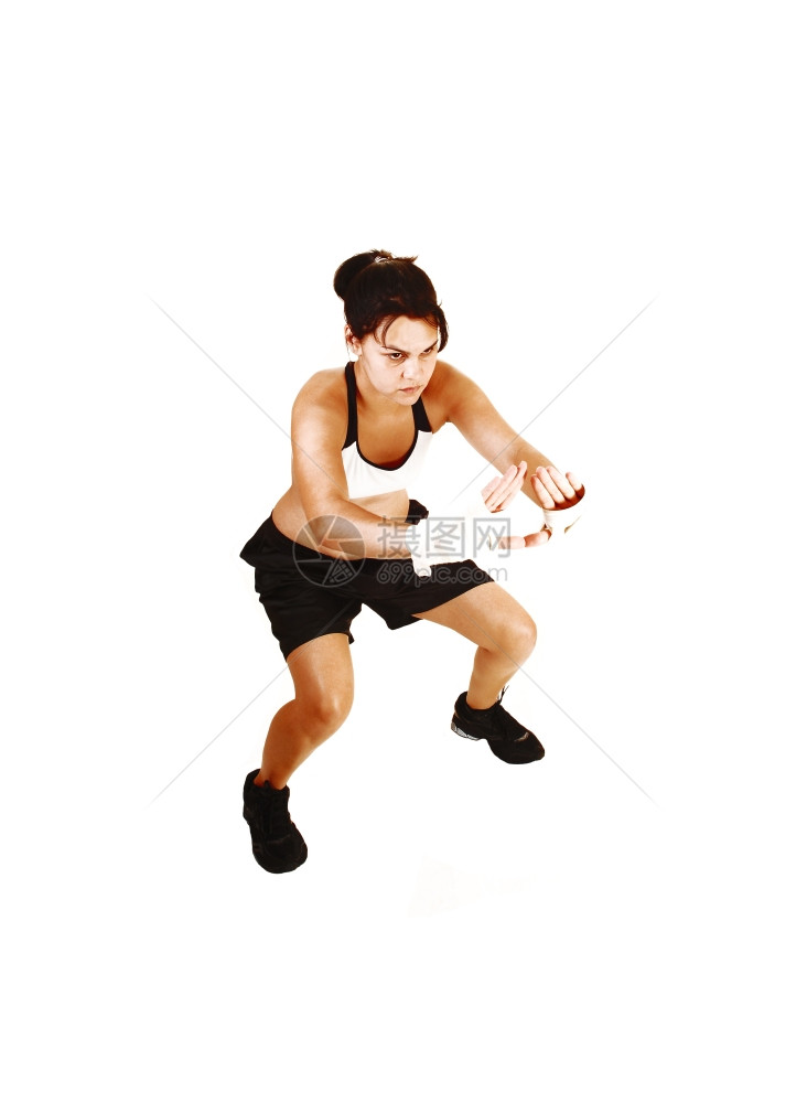 一名年轻女子为下一个拳击队的防御训练有很多白种背景的图片