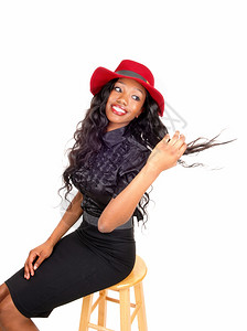 一个可爱的非裔美国女人穿着黑色的上衣长黑色卷发戴着红帽子图片