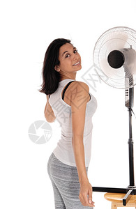 一位穿着灰色腿部的西班牙年轻女站在风扇前冷却热浪孤立于白色背景女在风扇上冷却背景图片
