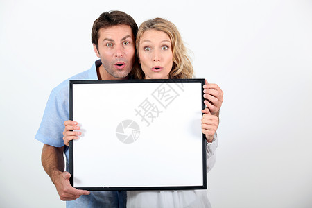 情侣拉着可笑的脸拿着空白板准备写你的短信图片