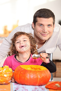 一个父亲和他的女儿笑着吃南瓜图片