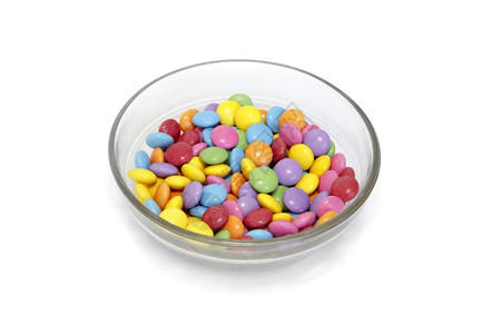 碗里亮彩色的糖果孤立在白色背景上图片