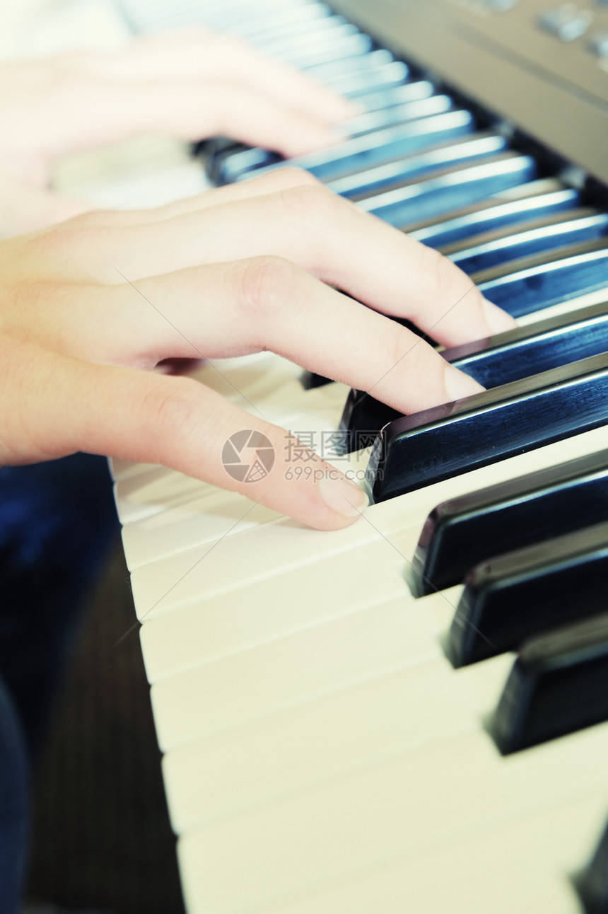 手放在钢琴的钥匙上照片贴温暖的颜色图片