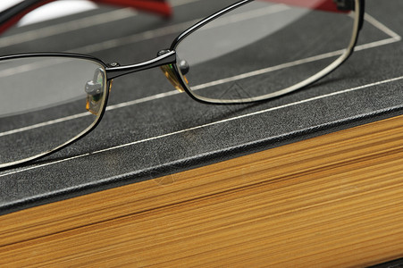 旧厚书上的眼镜照片贴上背景图片