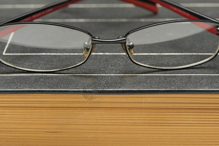旧厚书上的眼镜照片贴上背景图片