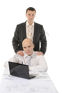 两名商人穿着业西装坐在明亮办公室的桌子上背景图片