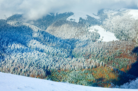 十月的山景第一次冬季雪和去年秋天的多彩叶子在遥远的山边丰富多彩的高清图片素材
