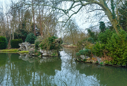 春天公园水面上有池塘和树木反射图片