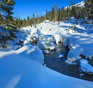 小山流有雪漂在边缘斜坡上有壁树图片