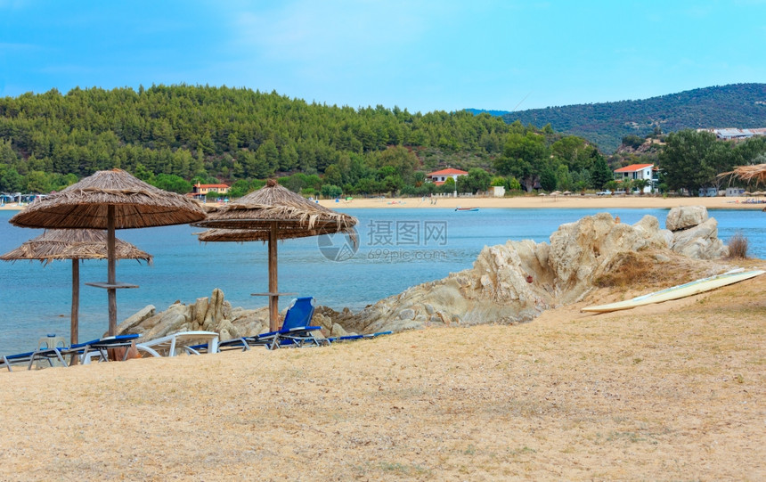 从利图斯海滩锡索尼亚恰基迪希腊的夏季清晨海景中看到有防晒罩和草药遮阳剂的沙滩西图尼亚恰基迪希腊图片