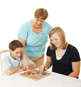 母亲和她的两个孩子一起玩棋盘游戏白人背景图片