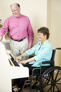残疾妇女弹钢琴而助理人员为她翻页图片