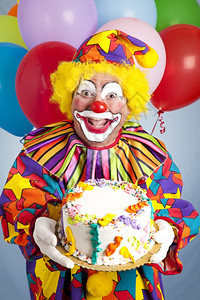 带着气球的疯狂小丑拿着生日蛋糕背景图片