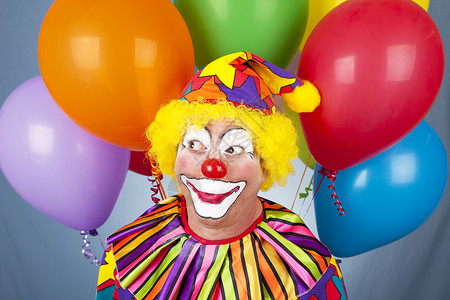 可爱的好心生日小丑周围都是多彩的气球图片
