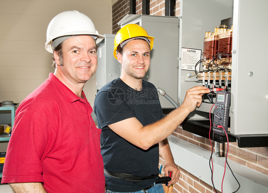 学徒电工和他的教官在电力分配中心读取电压图片