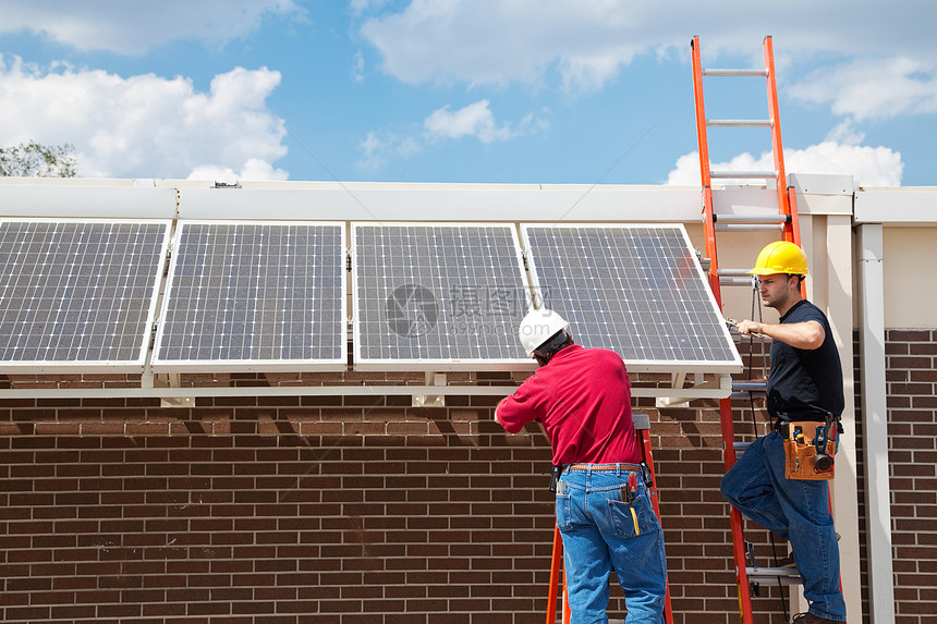 工人在一栋楼的侧安装太阳能电池板宽角视图有文字空间图片