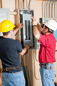 两名电工在业环境中修理电路断器板图片