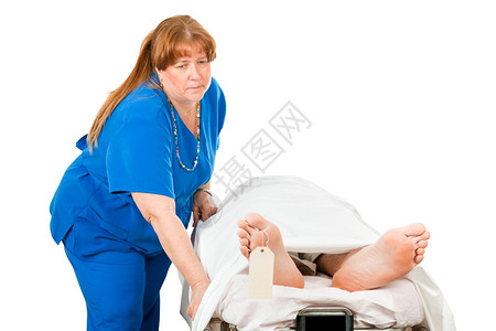 伤痛护士在医院轮椅上载着一位已故病人白着孤立无援背景图片
