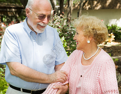 年长的情侣在花园散步医学的高清图片素材