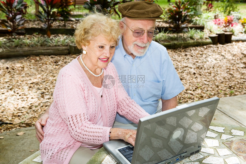 老年夫妇用笔记本电脑在户外图片