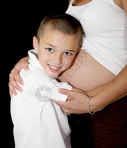 可爱的小男孩在听母亲怀孕的肚子图片