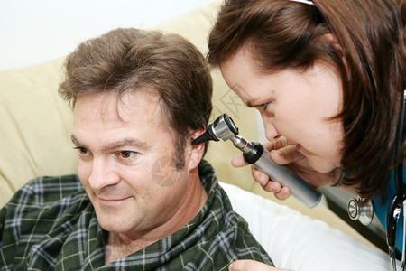 家庭保健护士使用显微镜检查病人的耳朵图片