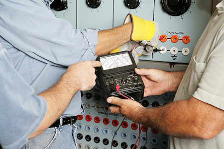 中小学生守则实际电工团队在业电力分配中心测试电压所有工作都按照业守则和安全标准进行给检查员注意仪表上的OHMS字是一个浮度单位不是商标背景