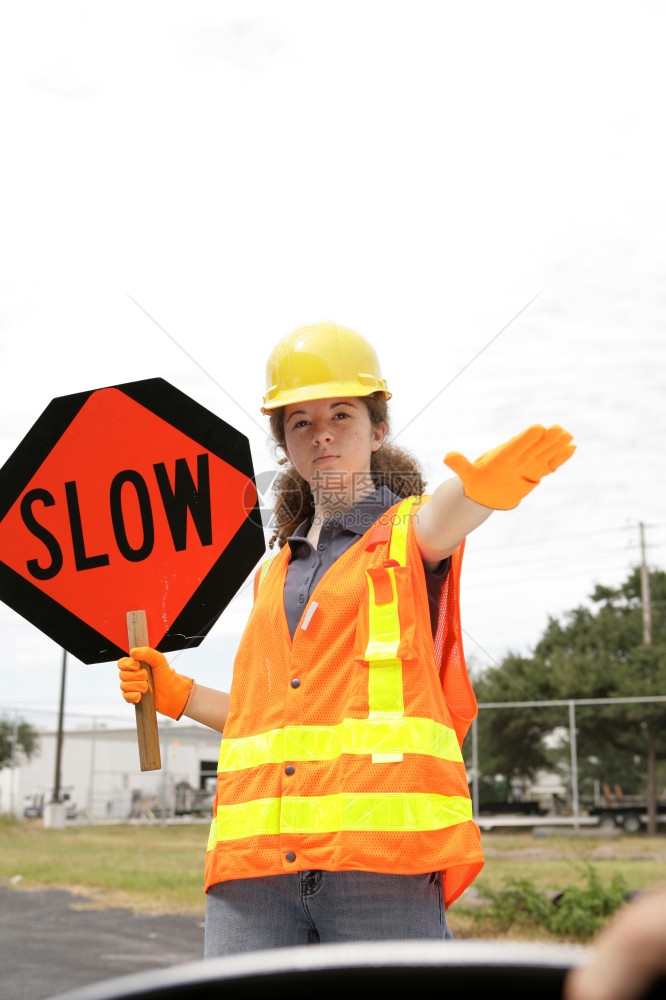 一名持有标志并指示司机减速的公路船员图片
