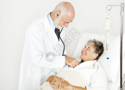 微笑的住院病人由英俊的医生检查图片