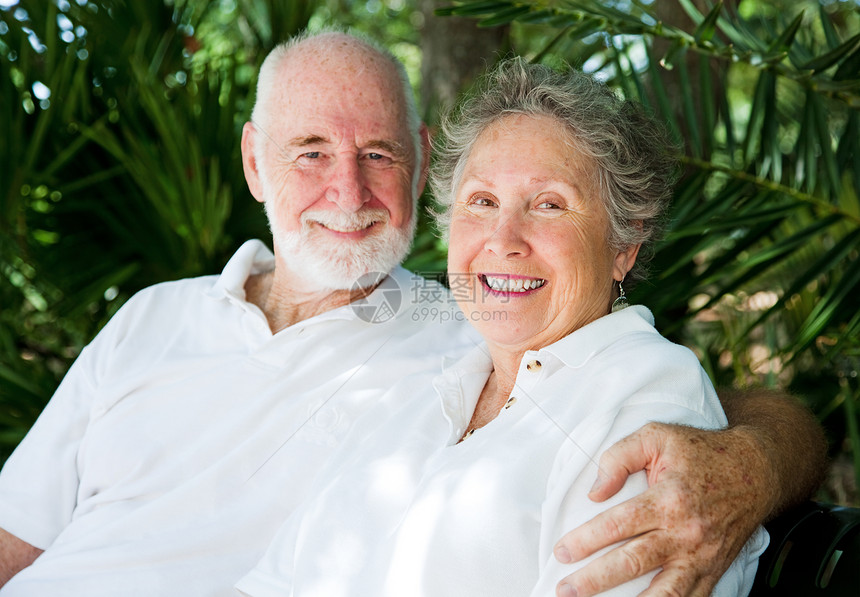 在热带棕榈山背景下网球白人中的老年夫妇充满了情感图片