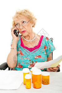 高级女在电话上与医疗保险公司讨论她的医疗账单白种背景图片