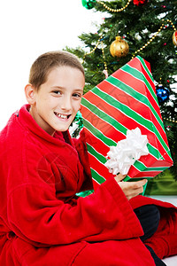 小男孩在圣诞节早上摇着礼物图片