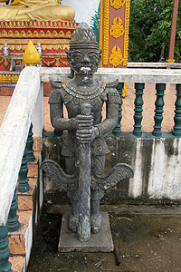 在老挝万象佛教修道院的圣殿金佛附近灰色水泥卫兵亚洲高清图片素材