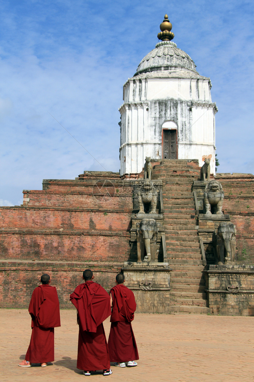 年轻僧侣仰望尼泊尔Bhaktapur的旧寺庙图片