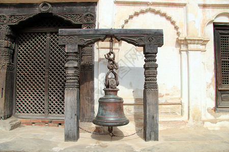 尼泊尔Bhaktapur宫殿木门附近的古铜铃背景图片