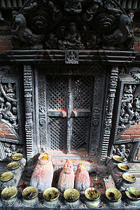 在尼泊尔巴克塔普尔的ChanguNarayan寺庙紧闭的大门附近的神像青铜高清图片素材