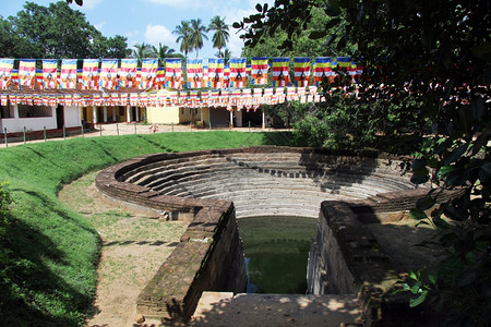 斯里兰卡Anuradhadhapura修道院的Pond和佛教旗帜图片