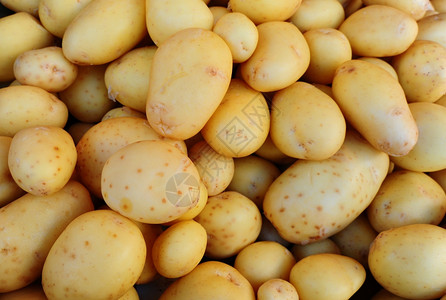 许多新鲜的土豆按背景排列图片