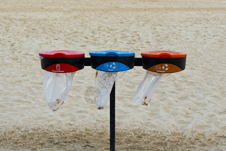 特拉维夫海滩上的蓝色和红回收容器垃圾集者回废物图片