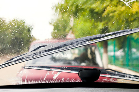 汽车擦雨器在中驾车时洗风挡玻璃背景